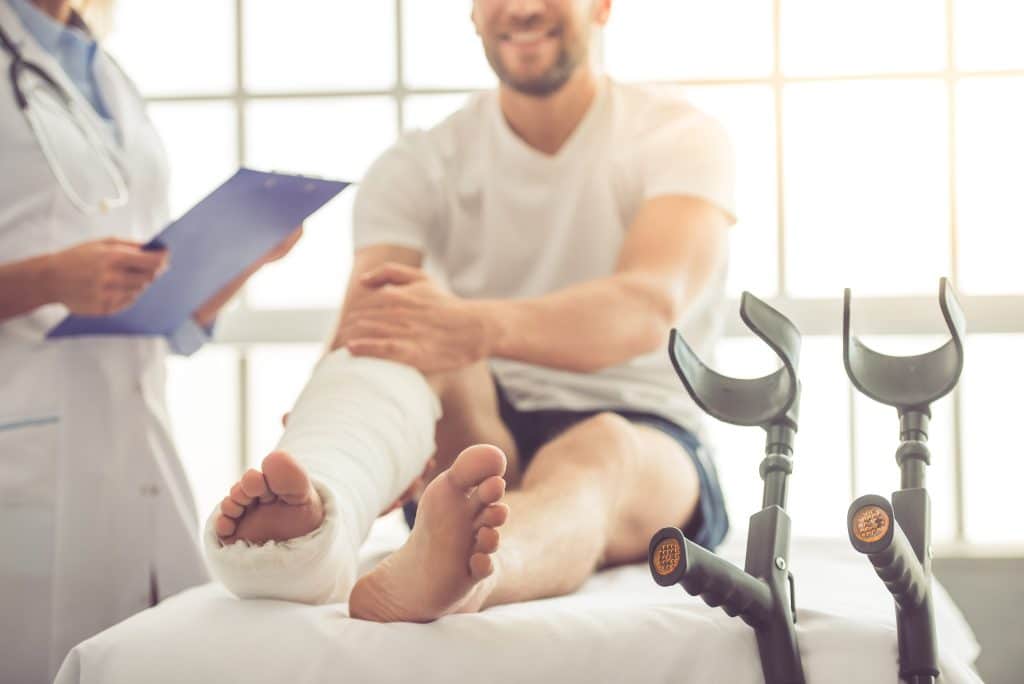 A patient with their foot in a cast speaking with a doctor.